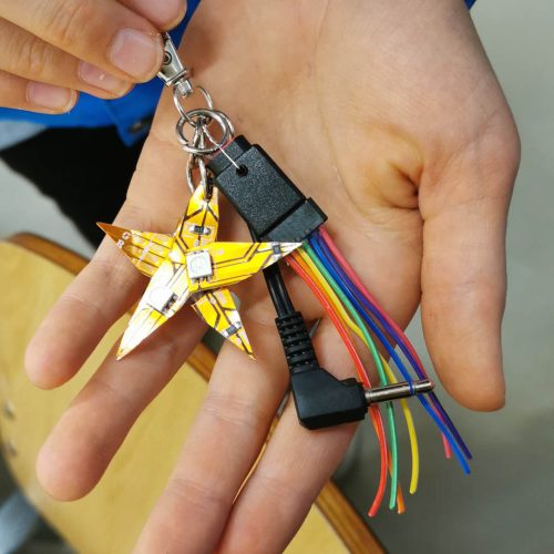 Bild: Eine Hand hält ein Kunststück aus Elektroschrott.