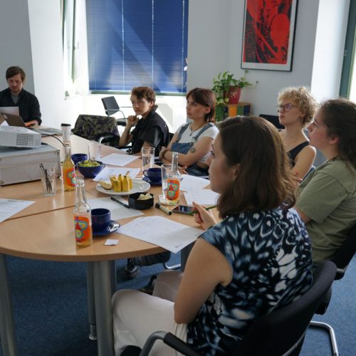 Die Mitglieder der Jugendjury sitzen gemeinsam an einem Tisch und beraten über die Aktionen die sie fördern möchten.
